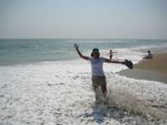 Sandra on beach at Cape Lookout, surf in..